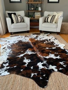 a living room with two chairs and a cowhide rug