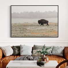 a living room with a couch, coffee table and painting on the wall above it