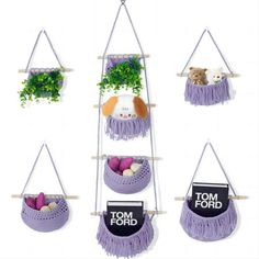 four hanging planters with plants and stuffed animals in them, each holding a sign that says tom ford