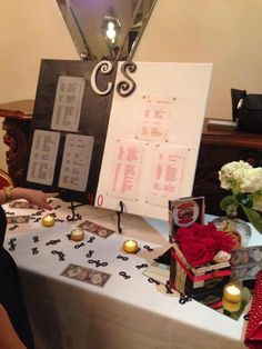 a table topped with cards and candles on top of a white tablecloth covered table