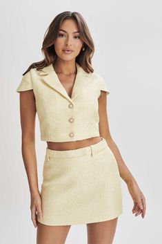 Elevate with ease.The MERCER Tweed Top boasts a V neckline complemented by a collar and lapel, offering a blend of classic sophistication and modern flair. Lined for comfort, it ensures a smooth and flattering silhouette. Featuring a button front and cap sleeves, it adds refinement to your ensemble, while the cropped length lends a chic and contemporary touch. Pair it with the Mercer Tweed Mini Skirt for a complete look. Tweed Top, Dresses Date Night, Fairy Floss, Cocktail Dress Prom, Tweed Mini Skirt, Beige Dresses, Basic Dress, Orange Dress, Swimwear Collection