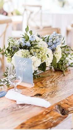 a wooden table topped with white and blue flowers