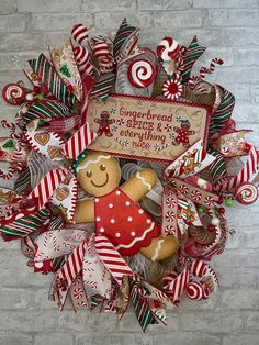 a christmas wreath with gingerbreads and candy canes on the front, along with a sign