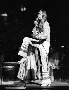 an old black and white photo of a woman on stage with a microphone in her hand