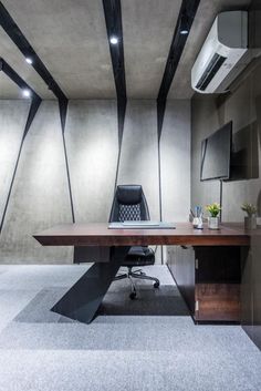 an empty conference room with a wooden table and black chair in front of a flat screen tv mounted on the wall