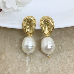 Pearl Drop Earrings are a blend of modern elegance and vintage charm.  Gold-filled and handmade, they feature classic white pearls that hang gracefully, making them a standout statement piece. Perfect as a bridesmaid gift, these earrings add a touch of sophistication and timeless beauty to any special occasion. *𝐏𝐑𝐎𝐃𝐔𝐂𝐓 𝐃𝐄𝐓𝐀𝐈𝐋𝐒* * 𝐌𝐚𝐭𝐞𝐫𝐢𝐚𝐥: Brass * 𝐏𝐥𝐚𝐭𝐢𝐧𝐠: Gold Plated * 𝐒𝐭𝐨𝐧𝐞: Sell Pearls. *𝐃𝐈𝐌𝐄𝐍𝐒𝐈𝐎𝐍𝐒* * 𝐖𝐞𝐢𝐠𝐡𝐭: 8 gm each * 𝐋𝐞𝐧𝐠𝐭𝐡: 3 Inche White Pearl Clip-on Earrings With Pearl Charm, Handmade Clip-on Earrings For Wedding, White Dangle Pearl Clip-on Earrings, White Dangle Clip-on Pearl Earrings, White Pearl Dangle Clip-on Earrings, Handmade Pearl White Drop Earrings, White Pearl Charm Drop Earrings For Bridal, Handmade Pearl White Drop Pearl Earrings, White Classic Drop Clip-on Earrings