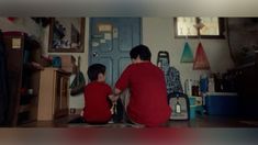 two boys sitting on the floor in front of a door