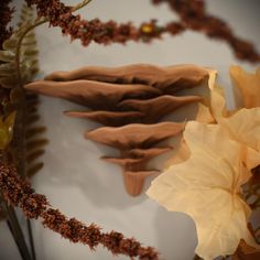 flowers and leaves are arranged on a white surface