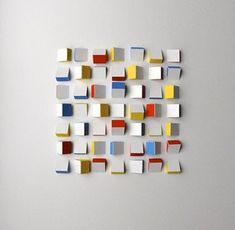 an abstract piece of art made out of squares and rectangles on a wall