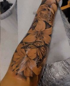 a person's arm with flowers and butterflies on it