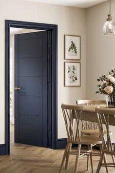 a dining room with a table and chairs next to a blue door