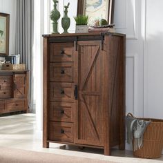 a wooden armoire with doors and drawers in a room next to a basket on the floor