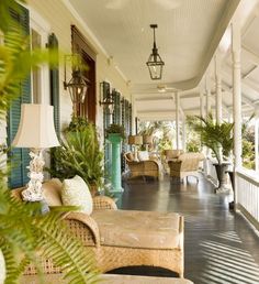 a porch with wicker furniture and green plants