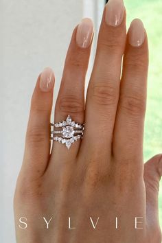 a woman's hand with a diamond ring on top of her finger and the words sylvie written below it