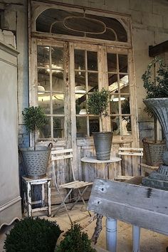 an old building with potted plants in front of the door and window sill