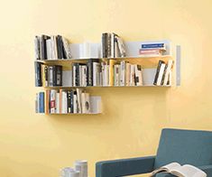 a living room filled with furniture and bookshelves next to a wall mounted book shelf