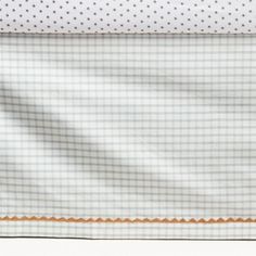 a white and blue checkered sheet with an orange border on the bottom half of it