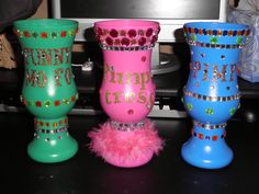 three different colored vases sitting on top of a black table next to a tv