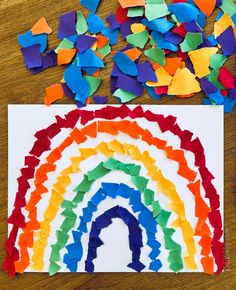 a paper cut out of a rainbow with confetti on the floor next to it