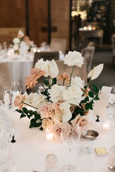 the centerpieces on this table are filled with flowers and candles