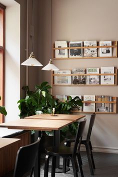 a dining room table and chairs with books on the wall