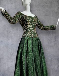 vintage 1980s evening dress by TERENCE NOLDER London, for your true Dynasty fantasy. Serious ball gown!   Fabric is definitely the star of this dress. Iridescent deep green, almost 3D, with a rich, tone on tone design. Darker threads alternate is a brighter green to give a luminescent appearance. Bodice is fitted with a wide neckline that sits just at the top of the shoulder.  Base fabric is covered with a gold metallic soutache in an abstract rose motif. Long sleeves end in a snap wrist. Skirt 1980s Prom, Abstract Rose, Prom Themes, Long Sleeve Ball Gowns, Gold Prom Dresses, Rose Motif, Full Circle, Evening Dresses Prom, Deep Green