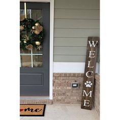 a welcome sign is next to a door with a dog's paw on it