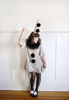 a woman dressed in a costume with black and white pom poms on her head