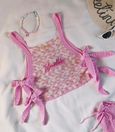 a pink and white top with the word barbie written on it next to some accessories