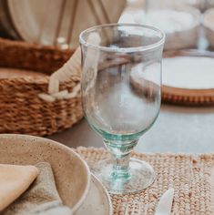 an empty wine glass sitting on top of a table next to a plate and napkin