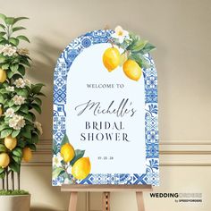 a welcome sign with lemons on it next to a potted plant and flowers