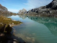 the mountains are reflected in the clear water