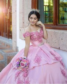 a woman in a pink dress is posing for the camera with her hand on her head