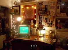 a laptop computer sitting on top of a wooden desk next to a lamp and pictures