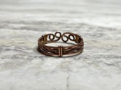 The perfect balance of masculine and feminine, this handcrafted braided copper ring is great for both men and women. Inspired by Viking-era desins, the copper wire is intricately braided to create a simple yet striking look.  Made from raw copper, the ring is open and adjustable to fit a range of sizes comfortably.  Carefully crafted with ancient artistry techniques, this ring is a unique, handmade accessory with a timeless design. If you are interested in a ring with a bit of a different style, Jewelry Mens, Wire Ring, Copper Ring, Wire Wrapped Rings, Mens Ring, Men's Jewelry Rings, Copper Rings, Unisex Ring, Adjustable Ring