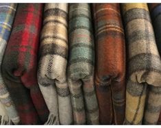 many different colored plaids are stacked on top of each other in the same row