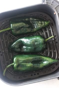 three green peppers sitting in an air fryer