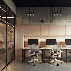 an office with three computer screens and two chairs