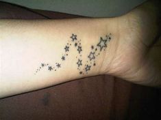 a wrist tattoo with stars on it