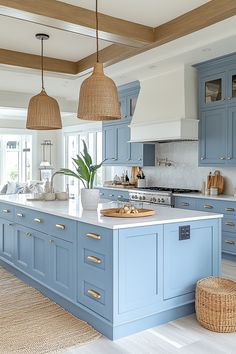 a large kitchen with blue cabinets and white counter tops, an island in the middle