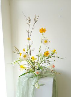 a vase filled with yellow and white flowers