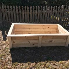 a wooden planter box sitting in the grass