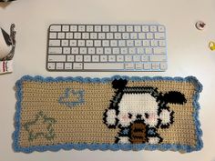 a computer keyboard sitting on top of a desk next to a knitted mouse pad