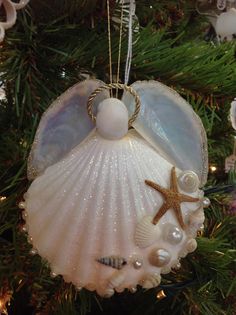 an ornament hanging from a christmas tree decorated with shells and seashells