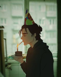 a person with a birthday hat blowing out a candle