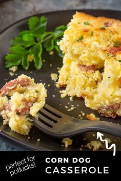 a piece of corn dog casserole on a black plate with a fork and parsley