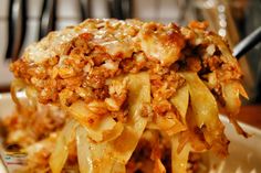 a close up of a plate of food with noodles and meat on it, ready to be eaten