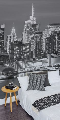 a bedroom with a large city skyline wallpapered in black, white and grey