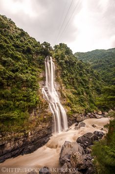 a large waterfall in the middle of a forest