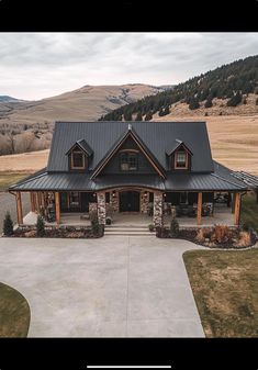 an aerial view of a house in the country side with mountains in the back ground